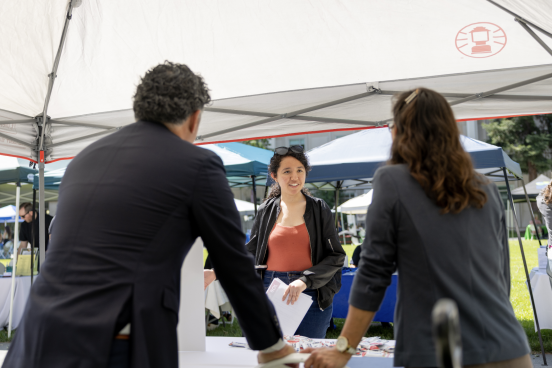 Student talking under an info tent
