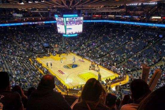 A packed stadium watches a basketball game