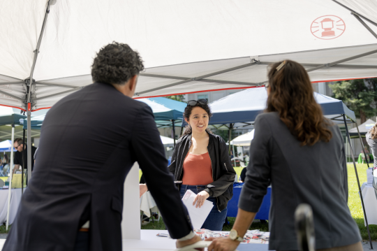 Student talking under an info tent